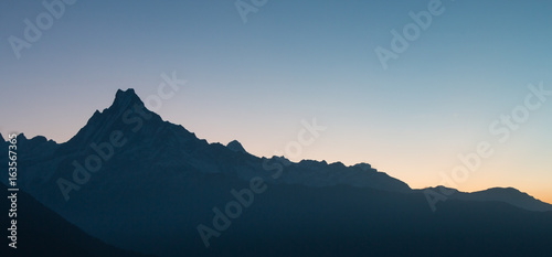 the sun is rising on the Machhapuchhre mountain in Nepal,