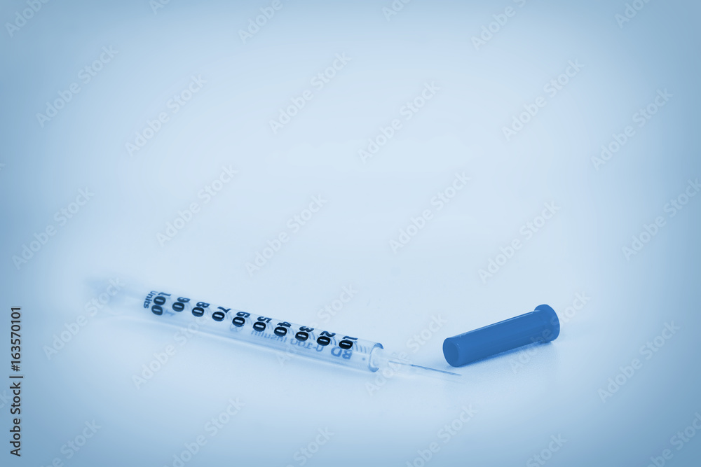 Obraz premium Blue tone of image of single insulin syringe isolated on white backgrounds