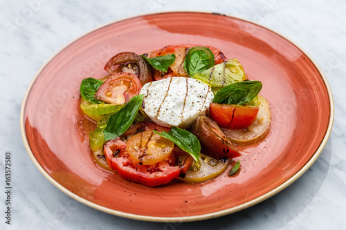 Caprese salad Tomato and mozzarella slices with basil