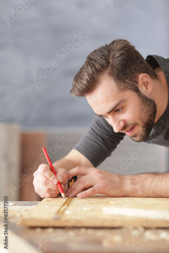 Carpenter applying marking ...