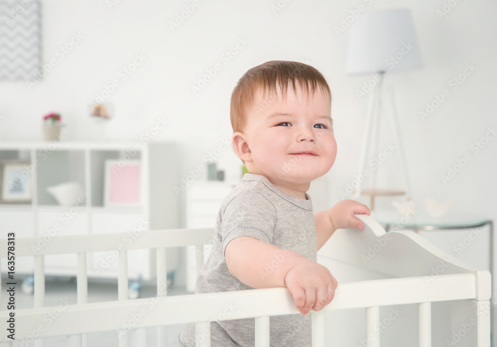 Cute little baby standing in crib at home Cute little baby standing in crib at home