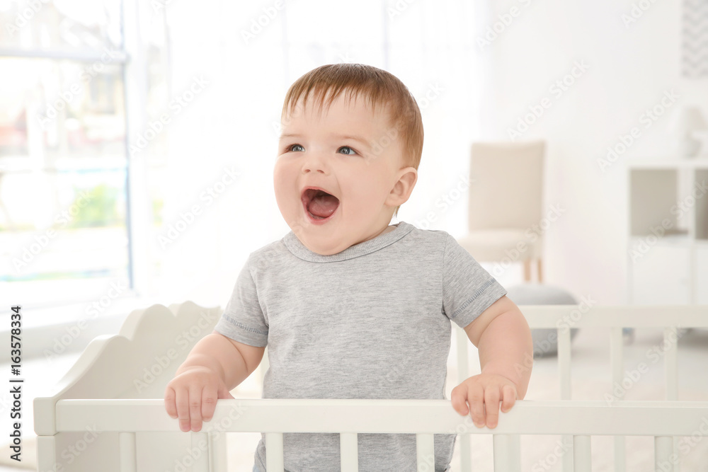 Cute little baby standing in crib at home Cute little baby standing in crib at home