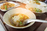thai noodle meat ball and soup with blur of papaya salad thai style spicy and sweet basil
