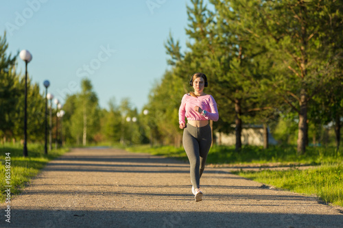 Young woman with headphones running in the Park