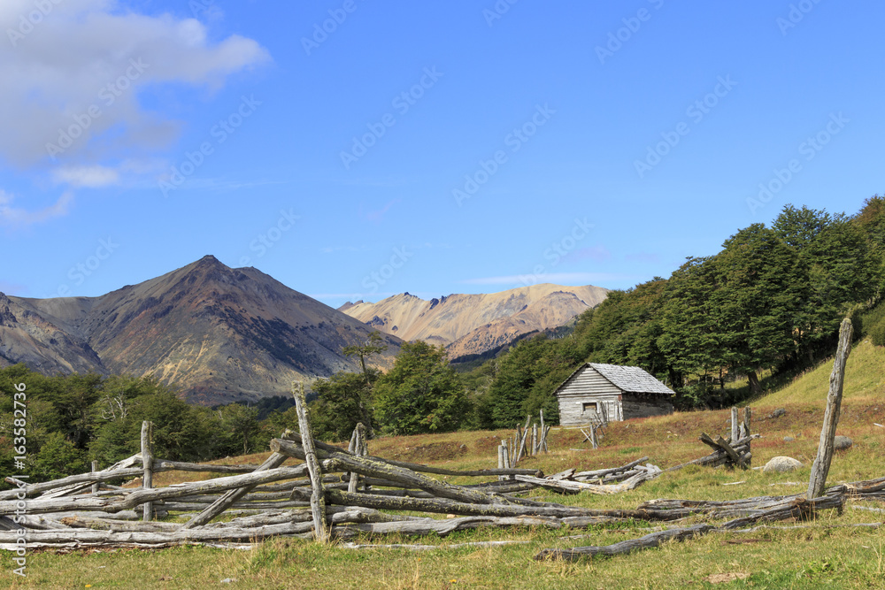 Old wooden fence and house in the mountains