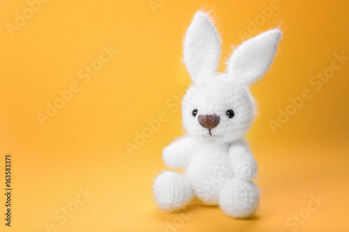 Cute handmade bunny toy on color background, closeup