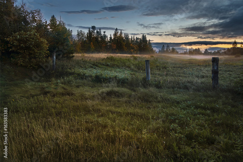 Mist rising at sunset over a feild along the Humber River, Humber Valley, Deer Lake, Newfoundland & Labrador