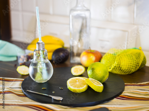 .Small design  jar with straw filled with infused water of lemon, straw. Fresh, summer mood. photo