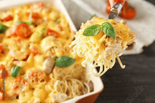 Spoon with delicious roasted turkey tetrazzini over kitchen table photo