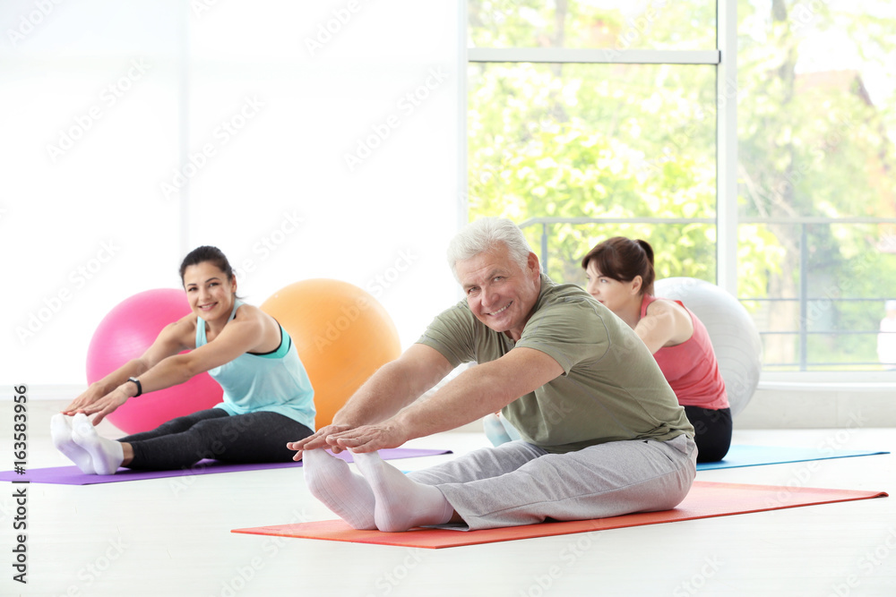 Group of people practicing yoga in gym Group of people practicing yoga in gym