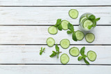 Glass of delicious cucumber lemonade on wooden background