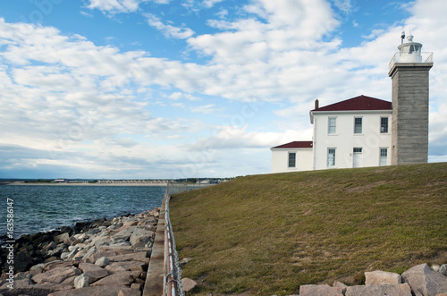Rock seawall protects Watch Hill lighthouse on rocky shore in Rhode Island. photo