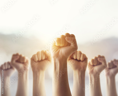 People raised fist air fighting for their rights with sunlight effect,  labor movement, election movement, copy space photo