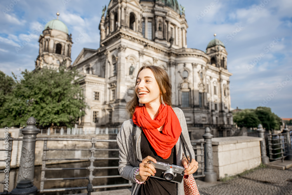 Young woman tourist with photo camera enjoying traveling in Berlin city walking near the famous cathedral