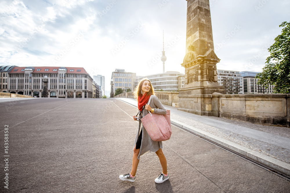 Fototapeta premium Młodej kobiety turystyczny odprowadzenie na Friedrich moscie podczas ranku w Berlin mieście