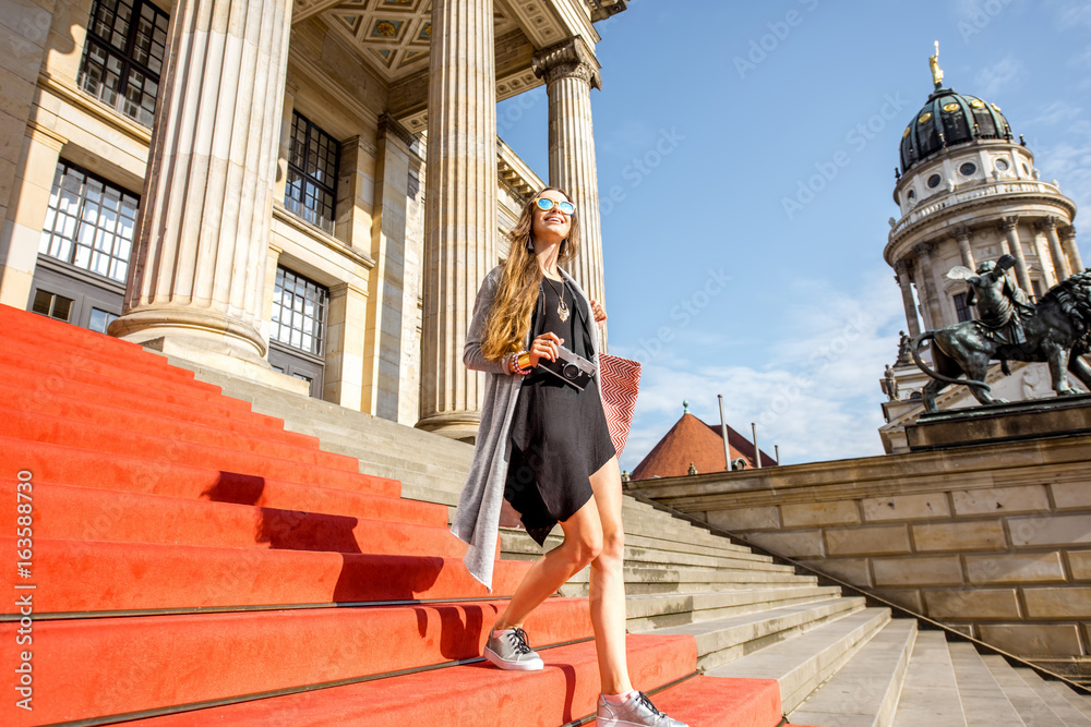 Fototapeta premium Young woman tourist walking on the stairs near the Concert house in Berlin