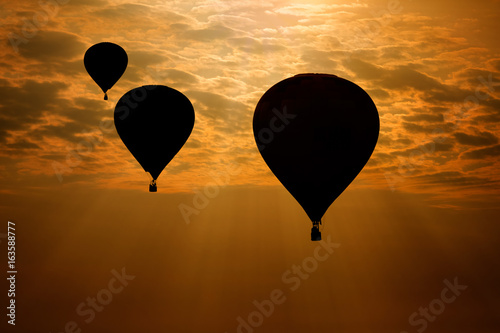 Hot air balloons silhouette against morning sky