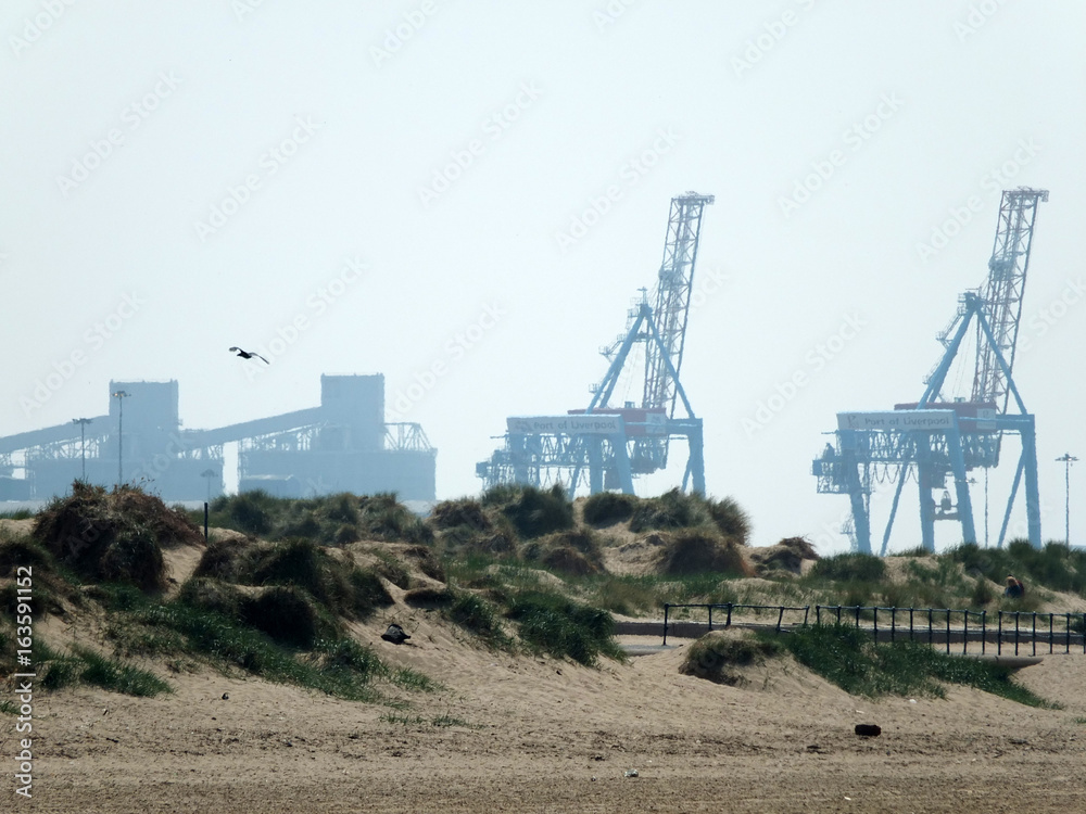 crosby beach in mersyside with cranes and sand dunes crosby beach in mersyside with cranes and sand dunes