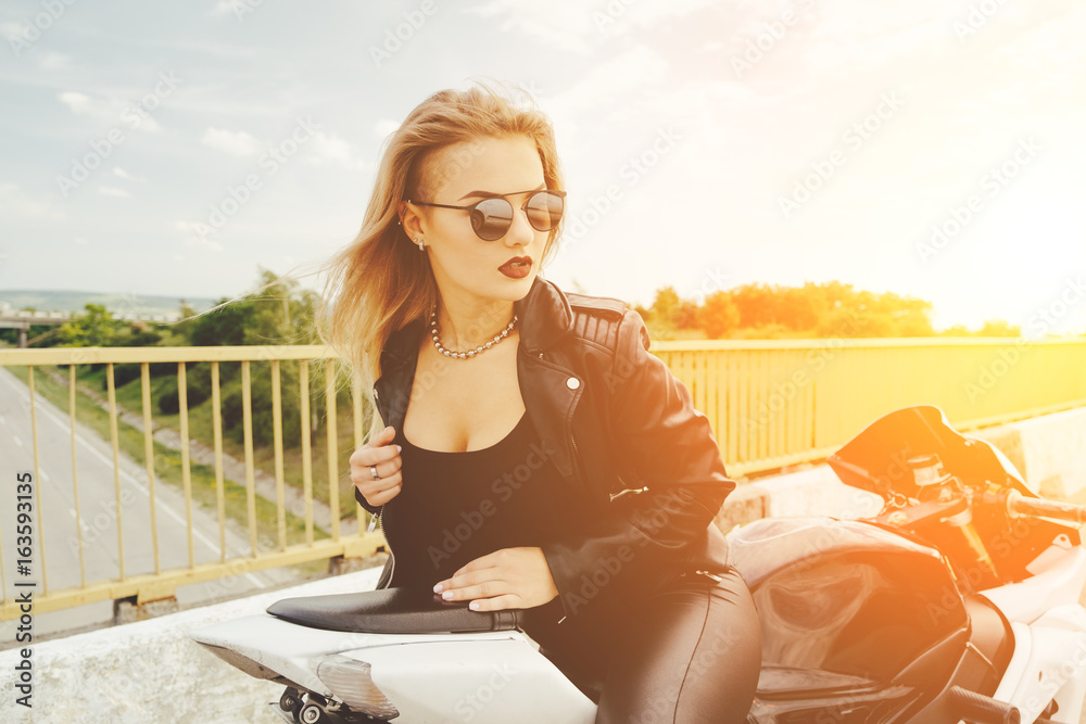 Fototapeta premium Biker girl in a leather clothes on a motorcycle