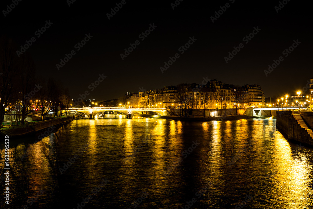 Night urban scene of a calm river crossing a big city