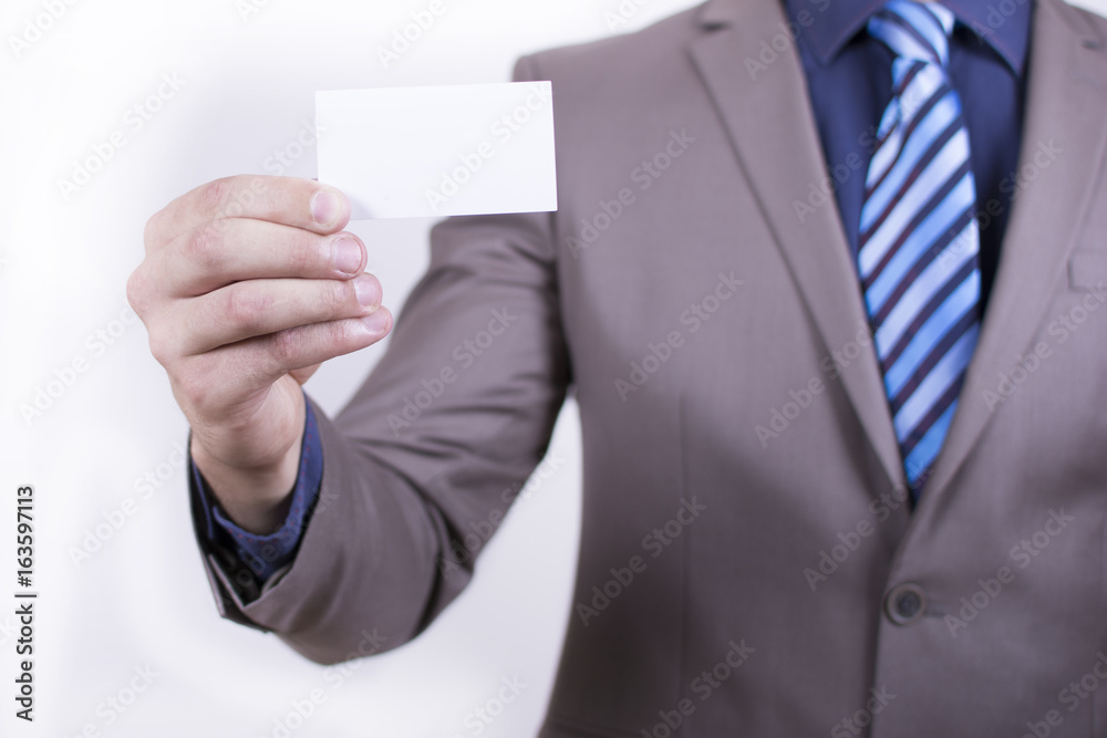 Close up view of a young businessman holding his business camera toward the camera white background. Copy space on the card. Close-up of a man giving a business card. Close up view of a young businessman holding his business camera toward the camera white background. Copy space on the card. Close-up of a man giving a business card.