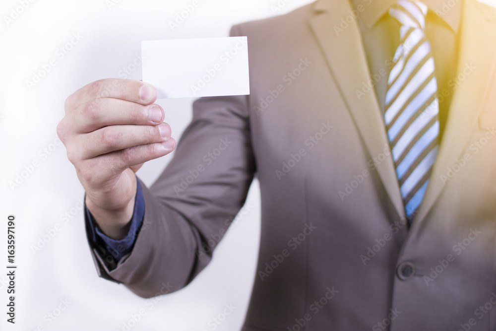Close up view of a young businessman holding his business camera toward the camera white background. Copy space on the card. Close-up of a man giving a business card. Close up view of a young businessman holding his business camera toward the camera white background. Copy space on the card. Close-up of a man giving a business card.