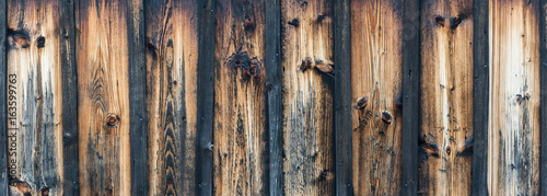 Blank striped wooden panoramic texture for background. Vintage faded wall with knots.