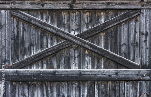 Vintage rural gate of barn with cross from laths.
