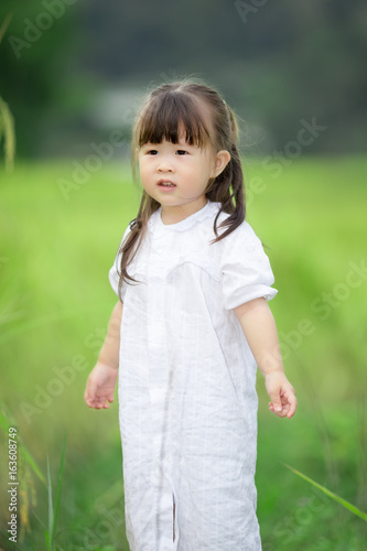 Happy cute little girl outdoors in summer day