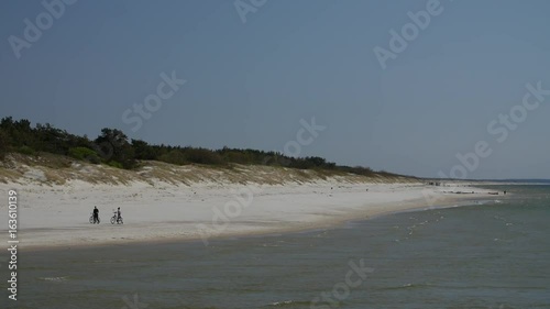 Ciclist on the Baltic sea beach, a wide shot. Slow motion. photo