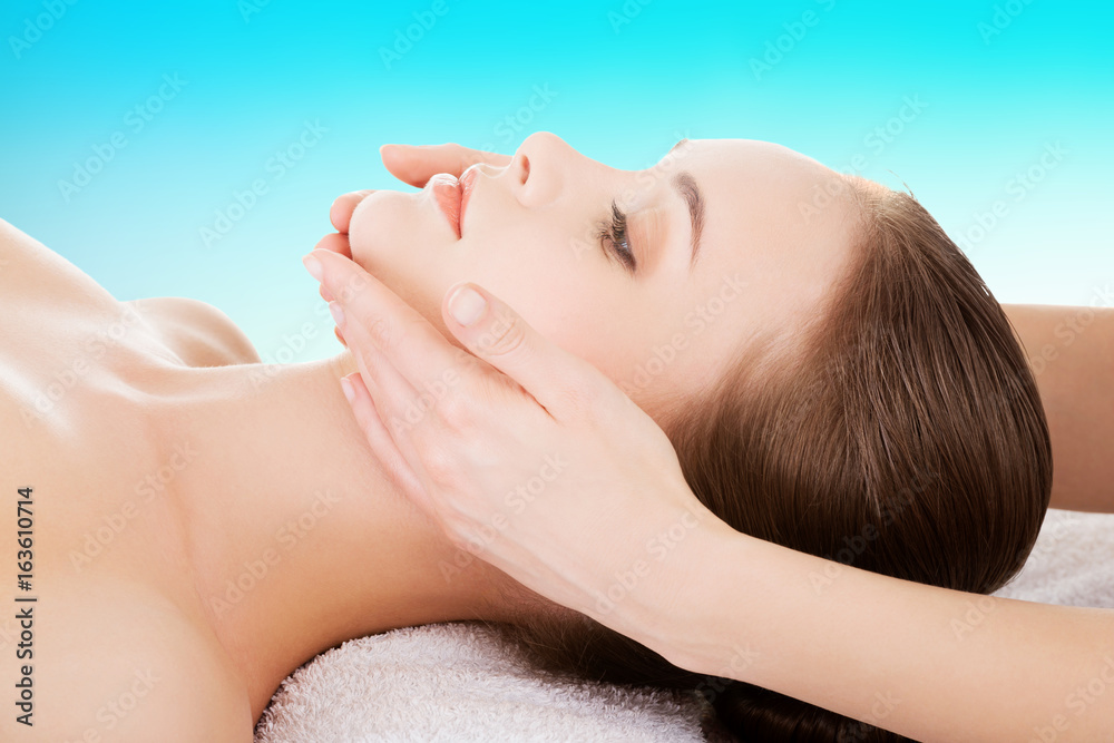Relaxed woman enjoy receiving face massage at spa saloon