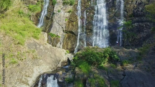 Flycam Moves up Slowly along Amazing High Waterfall photo