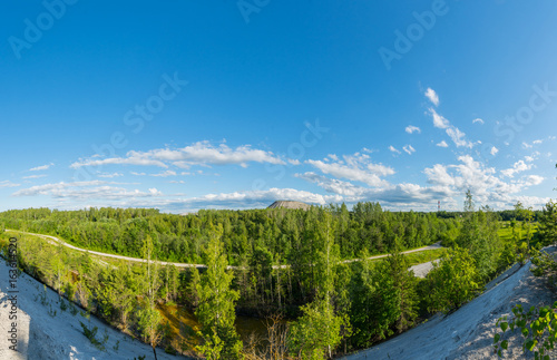 Amazing landscape view from the top of mountain. Forest and green fields panorama.