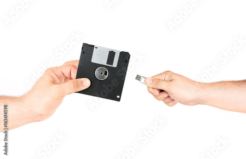 Hands Holding Floppy Disk Versus Flash Memory Stick Isolated On White Background