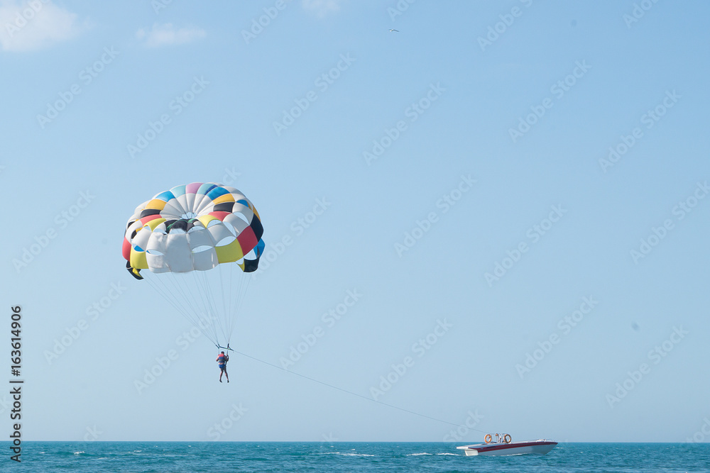 Parasailing is above the sea. Focus on a parachute. Space for text. Parasailing is above the sea. Focus on a parachute. Space for text.
