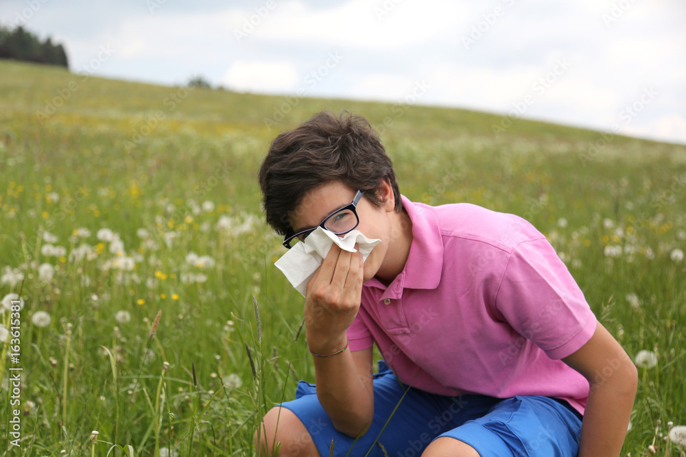 Allergic boy with glasses blows his nose Allergic boy with glasses blows his nose
