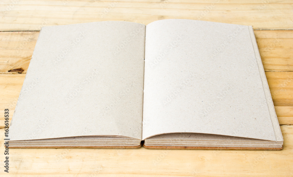 Open hand made book on wooden table. Open hand made book on wooden table.