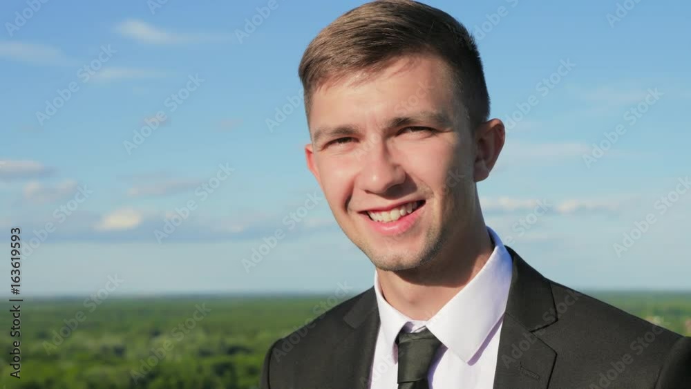 Portrait of an attractive businessman against the blue sky at sunset Portrait of an attractive businessman against the blue sky at sunset