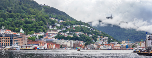 Panorama of historic, UNESCO World Heritage listed district Bryggen in Bergen. Visible hills Floyen with upper funicular station and Ulriken with characteristic top tower