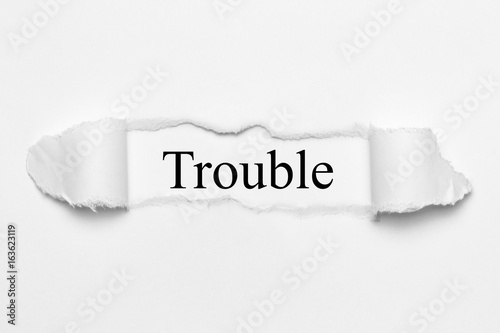 Trouble on white torn paper