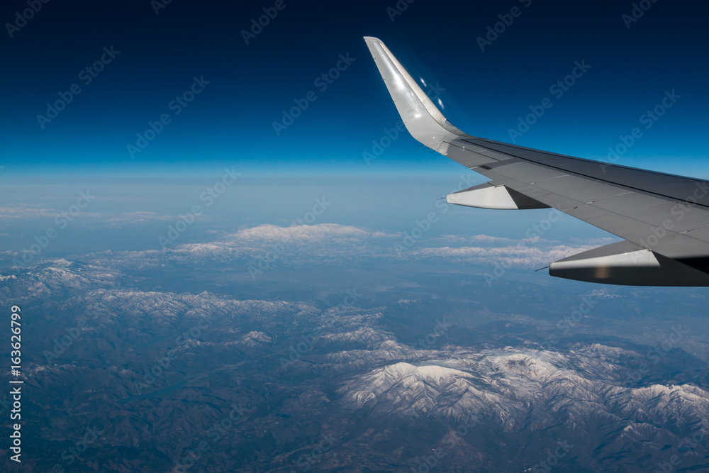 Wingtip of aircraft in flight feature the winglet with mountain in background Wingtip of aircraft in flight feature the winglet with mountain in background