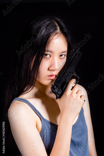 Teenage Asian girl with pistol