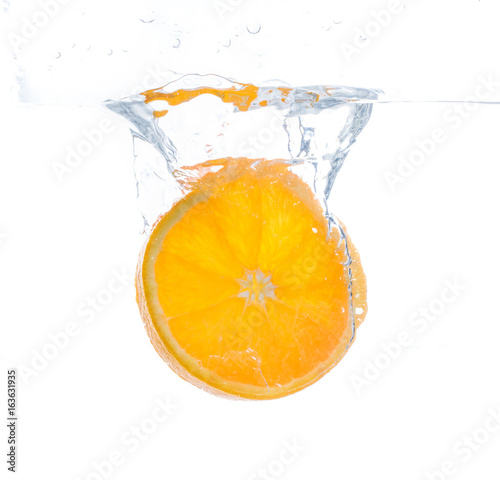 Fototapeta Naklejka Na Ścianę i Meble -  orange slice in water splash. white  background