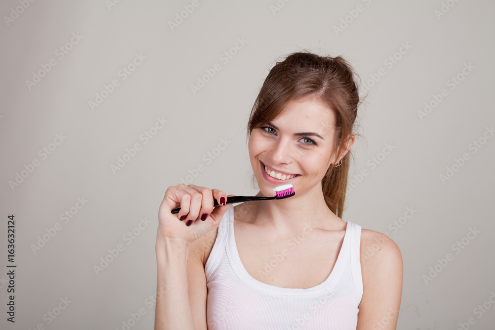 girl holding a toothbrush smiles girl holding a toothbrush smiles