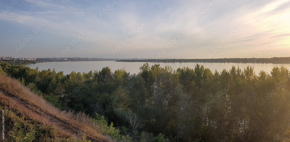 shore of the Volga river at sunrise in the sun