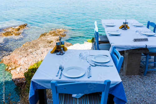 Empty tables of the restaurant on a cliff with an inscription reserved