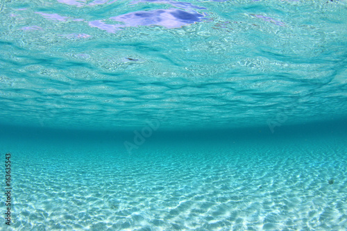 Underwater ocean background. Sandy sea floor and clear bue water