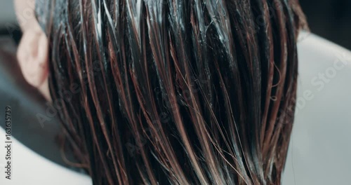 caucasian woman in salon has a hair treatment with professional hair dresser.
