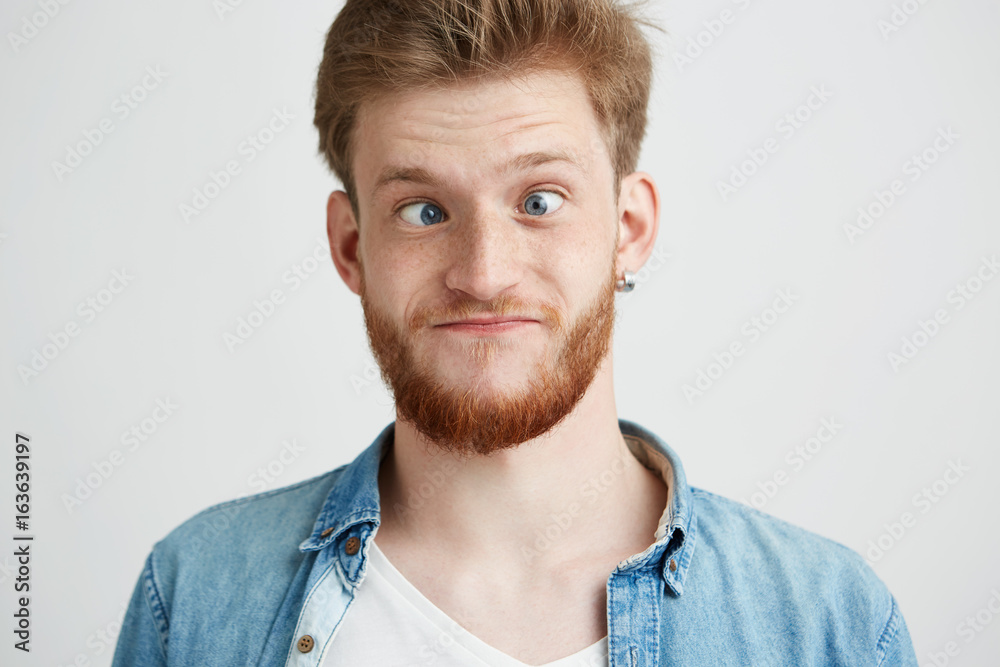 Portrait of young cheerful merry guy making funny face fooling looking at camera over white background. Portrait of young cheerful merry guy making funny face fooling looking at camera over white background.