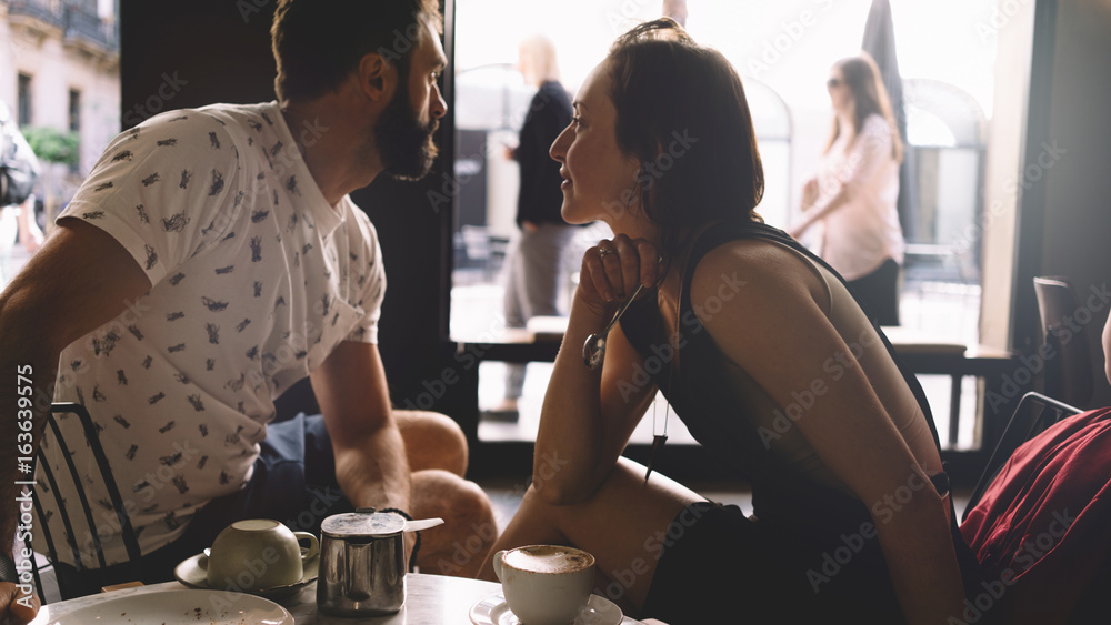 Φωτογραφία Couple of young beautiful people is sitting in a modern coffee shop on a summer day